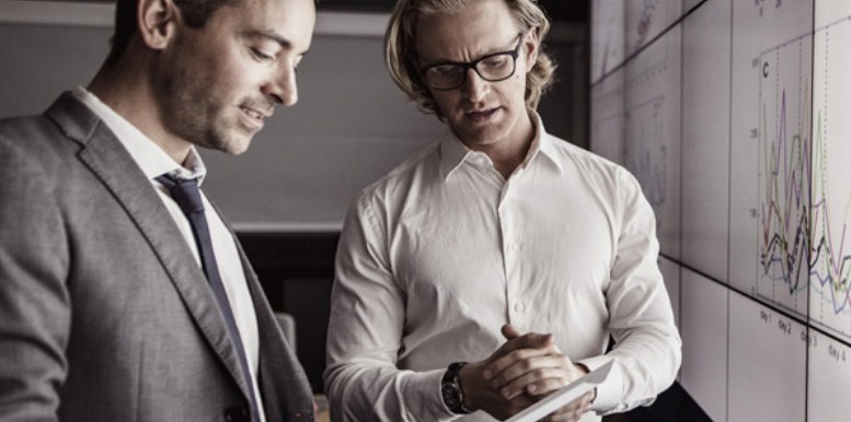 Engineers reviewing measurement data trends on a tablet